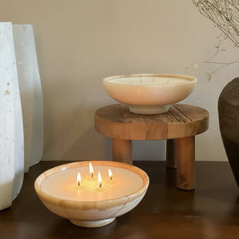 Decorative setting with ceramic bowls and vases on a wooden surface.