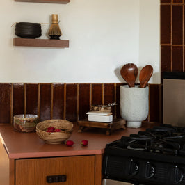 Kitchen with wooden cabinets, stainless steel stove, and brown tiled backsplash.
